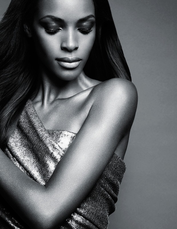 Black and white close up portrait of a woman in a metallic strapless dress with long dark hair looking down