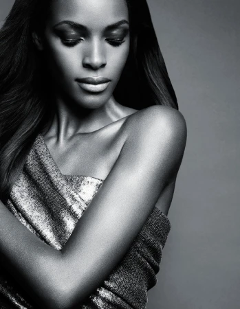 Black and white close up portrait of a woman in a metallic strapless dress with long dark hair looking down