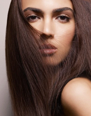 Close-up portrait of a woman with long brown hair framing her face, captured by photographer Philippe Salomon.