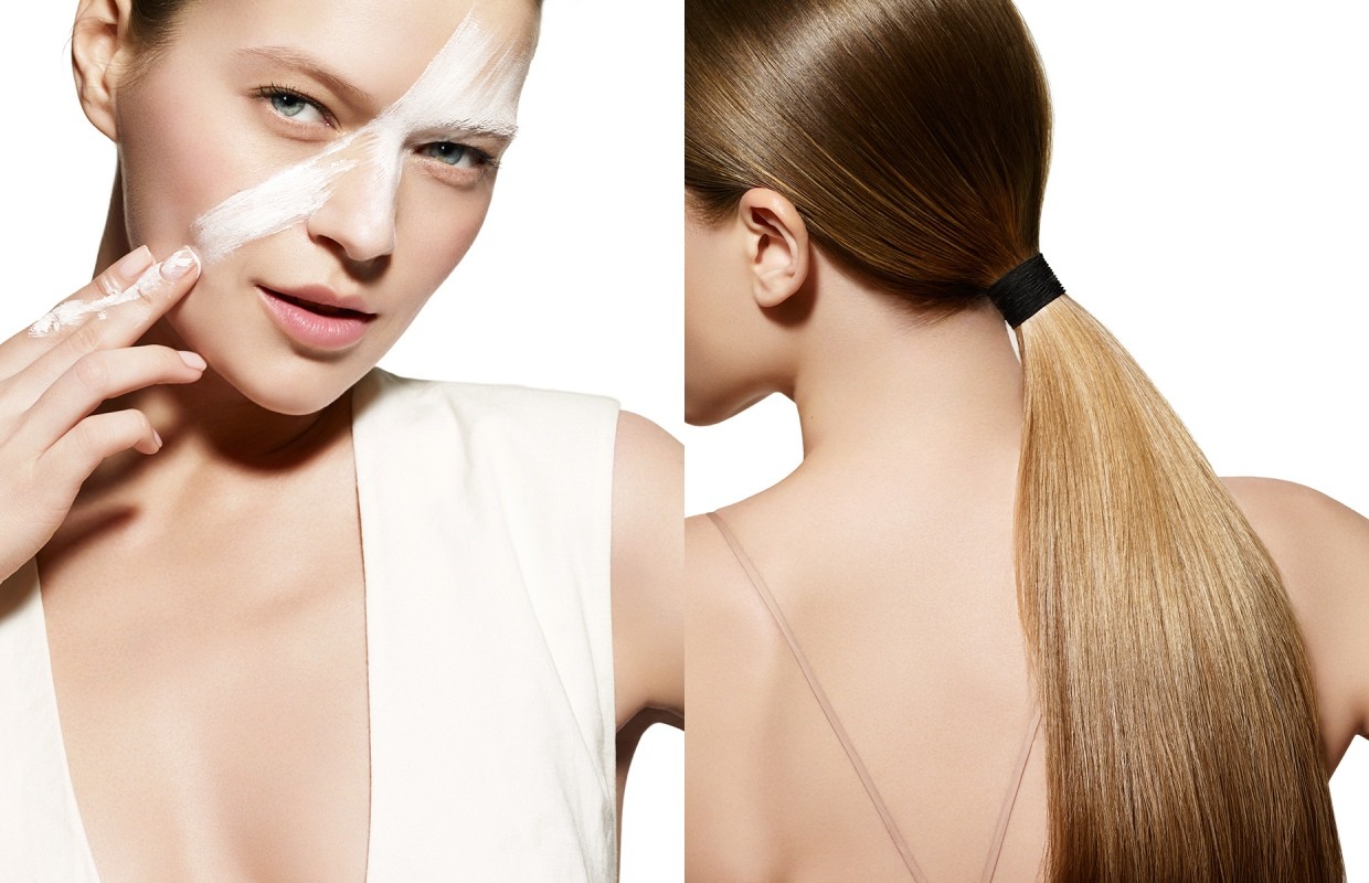 Beauty portrait featuring a woman with blonde hair and makeup application, viewed against a clean white background, for cosmetic advertising.