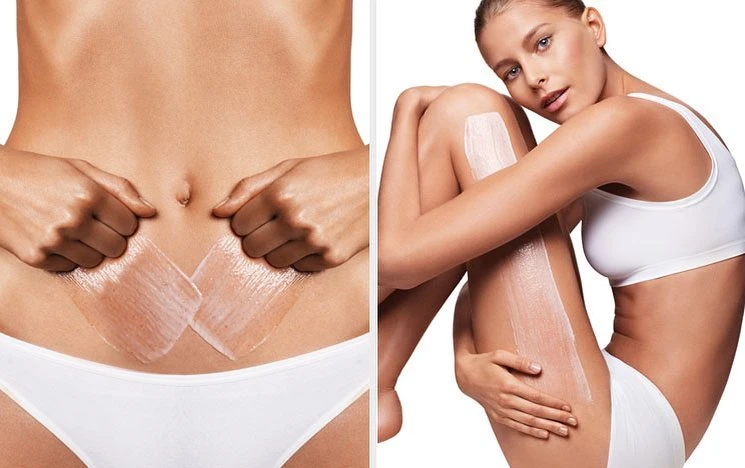 Studio shot of a fair-skinned young woman with an athletic build and bare midriff; product is being applied to her torso and legs.