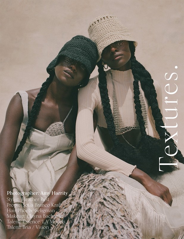 Two Black fashion models in bucket hats pose in a studio, showcasing knit textures, neutral tones, and unique braids in a minimalist aesthetic.