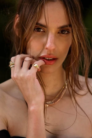 Close-up portrait of a woman touching her lip with rings on her fingers, styled by Phoebe Seligman in Los Angeles.