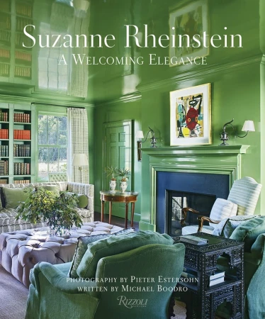 A glossy green living room interior featuring upholstered armchairs, a fireplace, and bookshelves by Pieter Estersohn