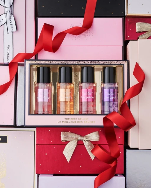 Victoria's Secret fragrance mist set, featuring four colorful bottles arranged in a gold-lined box, ribbons, and gift boxes.