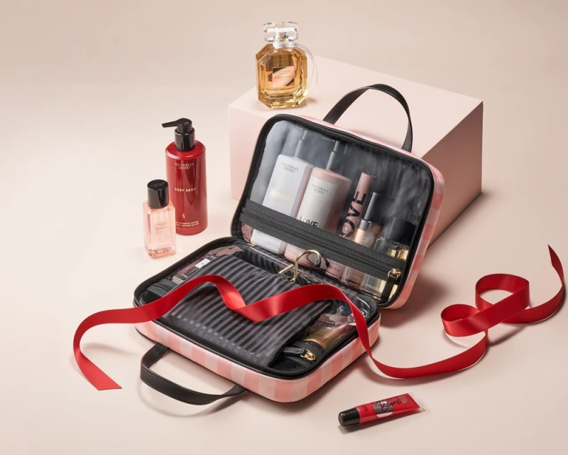 Cosmetic bag filled with beauty products, including perfume, body wash, and lotion, displayed against a neutral backdrop.