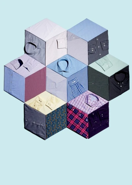 Arrangement of cubes covered with fabric shirts in different colours and designs, forming a honeycomb pattern against light blue.