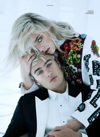 Close-up portrait of two models, a blonde woman leaning over a man in a tuxedo, styled by Rafael Linares