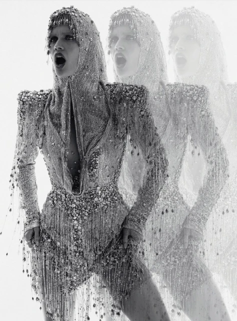 Fashion editorial shot of a woman in a beaded hood and bodysuit, captured in a triple exposure effect against a bright white background.