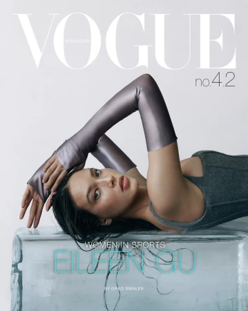 Vogue Hong Kong cover featuring Eileen Gu in grey top and arm sleeves, lying on an ice block, shot in a studio environment.