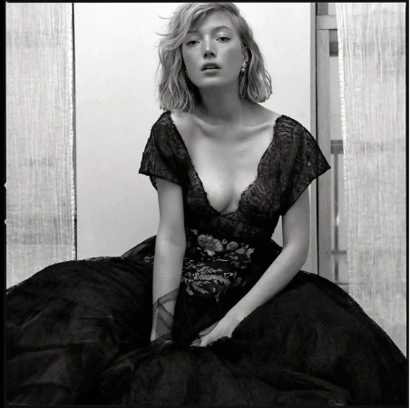 Portrait of a woman wearing a dark lace dress with floral embroidery, styled with hair by Rebecca Plymate in Los Angeles.
