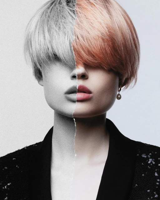 Portrait of a woman with two-toned hair, half grey and half peachy-orange, wearing a sequined blazer against a neutral background.