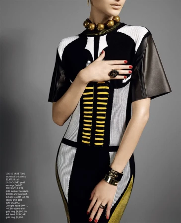 Model wearing a black, white, and yellow patterned knit dress with gold collar necklace and rings, styled by nail artist Roseann Singleton