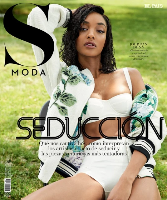 Jourdan Dunn graces the cover of S Moda magazine. The model wears a white bra top and jacket, and is set against a green backdrop.