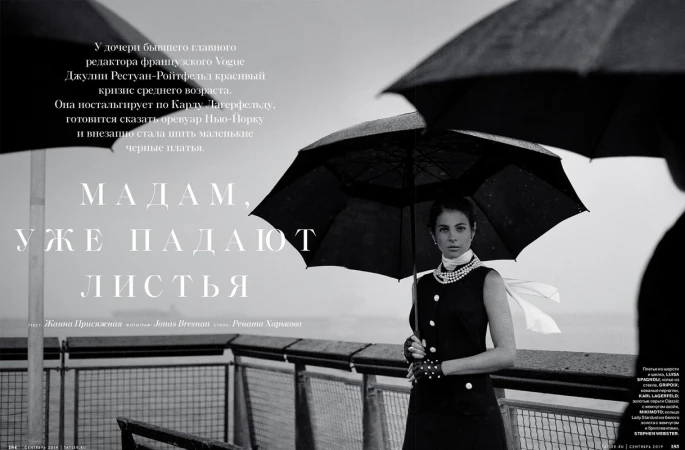 Black and white magazine cover featuring a woman in a dark dress holding an umbrella, pearls, with large text and sea background.