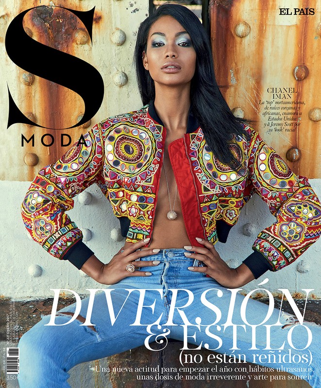 Magazine cover featuring a model in an ornate jacket and jeans, posing against a rustic metal backdrop with visible text overlay.