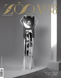 Black and white editorial magazine cover featuring a model holding a mirrored prop reflecting her face in a long patterned dress