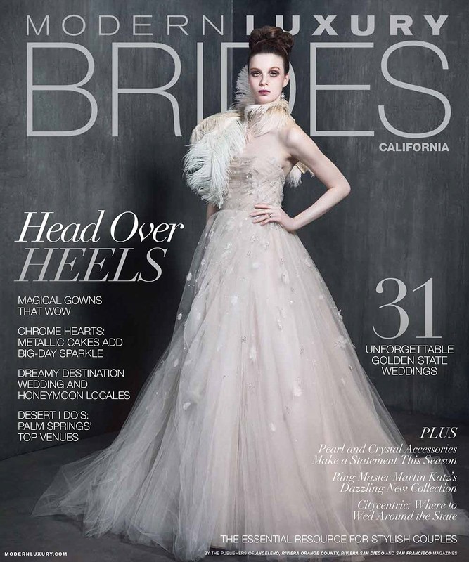 Modern Luxury Brides magazine cover featuring a woman in a wedding gown, feathered collar, and elegant updo against a gray backdrop.