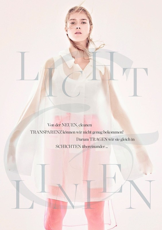Woman in a sheer top, transparent dress with light pink lining, standing in a light pink room in a fashion editorial photoshoot.
