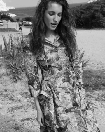 Monochrome fashion portrait of a woman wearing a patterned long-sleeved coat outdoors in Los Angeles by photographer Sarra Na.