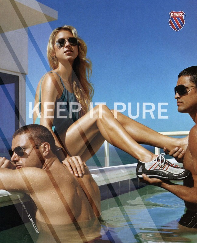 Outdoor fashion advertising shot featuring two shirtless men and a woman in a swimsuit by a pool, promoting K-Swiss footwear.