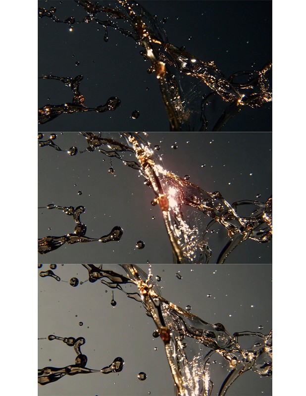 Water suspended in motion catches light. Liquid droplets and strands display dynamic movement against changing grey and black backgrounds.