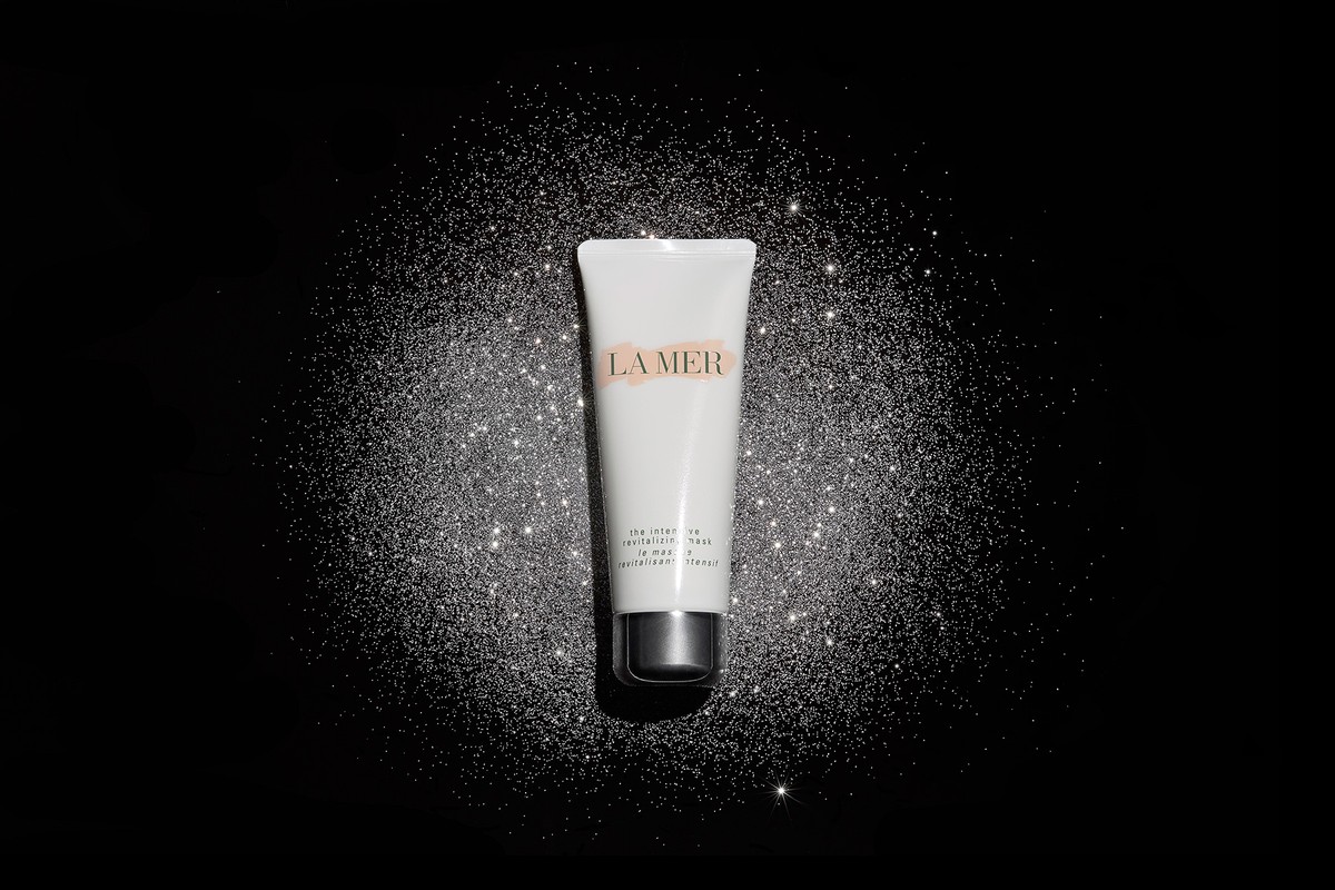 La Mer revitalizing mask tube on black glitter background. Beauty product shot with luxurious feel, studio lit, product focus.