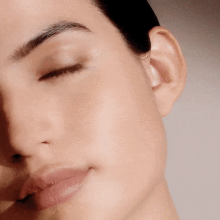 Close-up beauty portrait of a woman with her eyes closed, shot by photographer Sesse Lind against a neutral background.