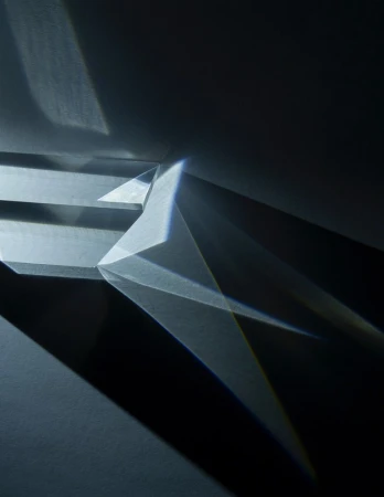 Abstract composition features geometric prisms and light interplay, creating shadows and refractions in a monochromatic color scheme.