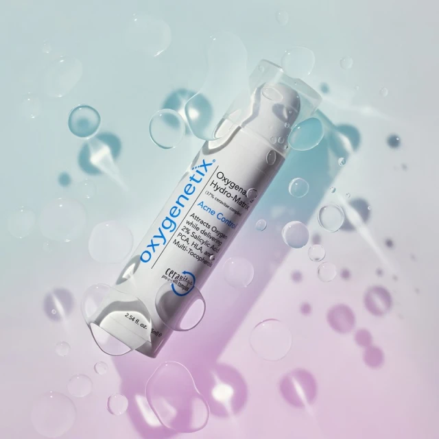 Cosmetic product, Oxygenetix Hydro-Matrix Acne Control, against a softly gradient blue and pink backdrop with water droplets.