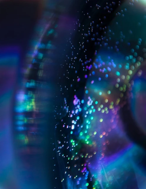 Abstract dark blue and black macro photography with bokeh light effects and lens flare, creating a futuristic visual aesthetic.