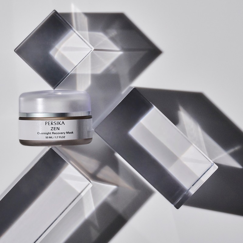 Product shot of Persika Zen overnight recovery mask with geometric transparent shapes on a white background, studio lighting.