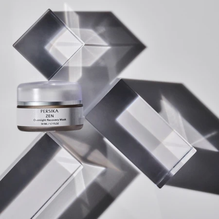 Product shot of Persika Zen overnight recovery mask with geometric transparent shapes on a white background, studio lighting.