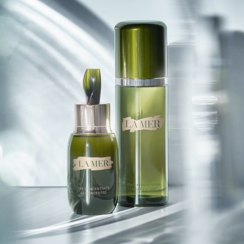 Two bottles of La Mer skincare products, one a concentrate with a dropper and the other a lotion, displayed against a light background.