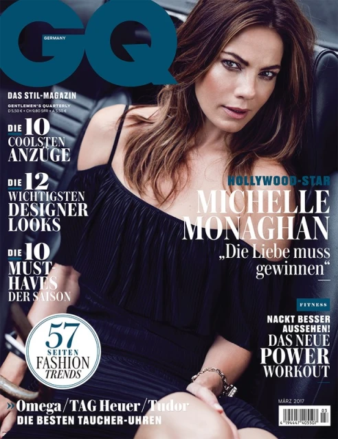Michelle Monaghan graces the cover of GQ Germany, seated in a car wearing a chic black dress against a backdrop of magazine text.