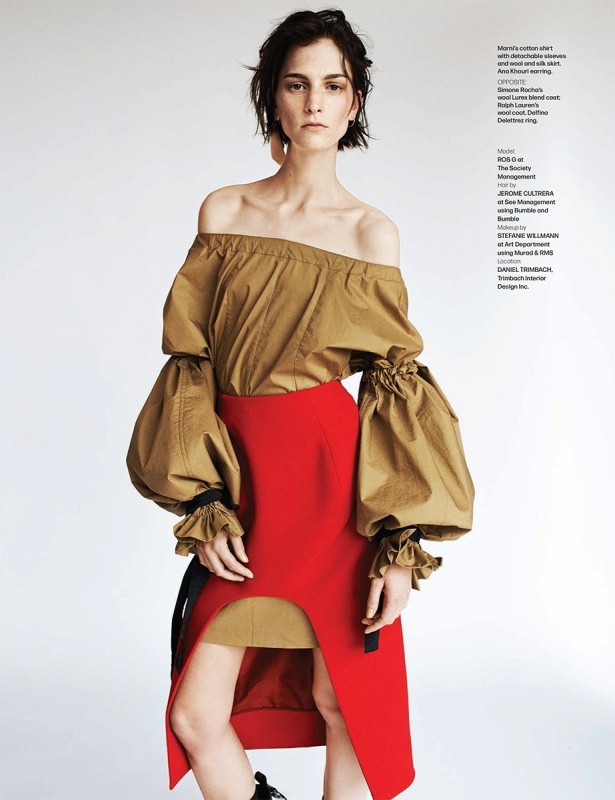 Fashion editorial shot of a slender adult woman in an off-shoulder blouse and red skirt against a bright neutral background.