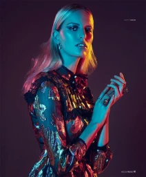 Portrait of a blonde woman in a metallic patterned dress under dramatic blue and red studio lighting