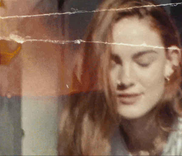 Close-up of a woman with blonde hair looking down, filtered with a vintage effect, creating a nostalgic and intimate mood.