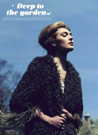 A woman wearing a textured dark fluffy coat against a clear blue sky background with visible editorial magazine typography.