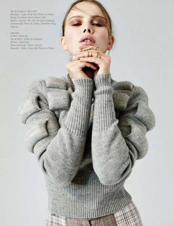 Portrait of a woman wearing a grey textured sweater with hands held to her face, featuring make-up by Stephanie Peterson.