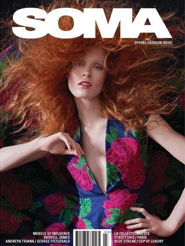 Magazine cover featuring a model with voluminous red hair wearing a blue floral dress, promoting the spring fashion issue and various fashion themes.