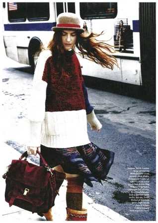 Woman in color-block sweater and bowler hat walking past a bus in Los Angeles, styled by Stephanie Peterson.