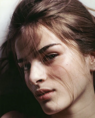 Close-up portrait of a woman with loose brown hair falling across her face and natural makeup in Los Angeles.