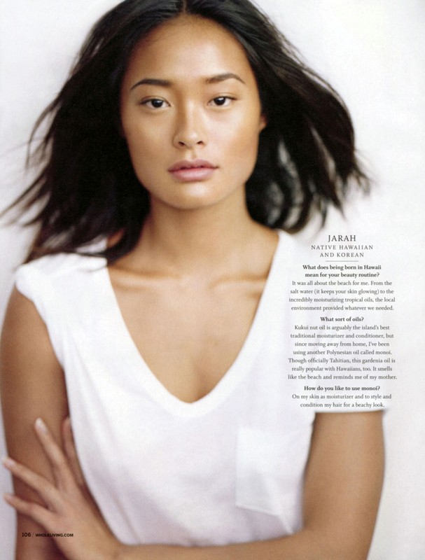 Portrait of a woman with long dark hair wearing a white v-neck t-shirt against a plain white background with printed interview text