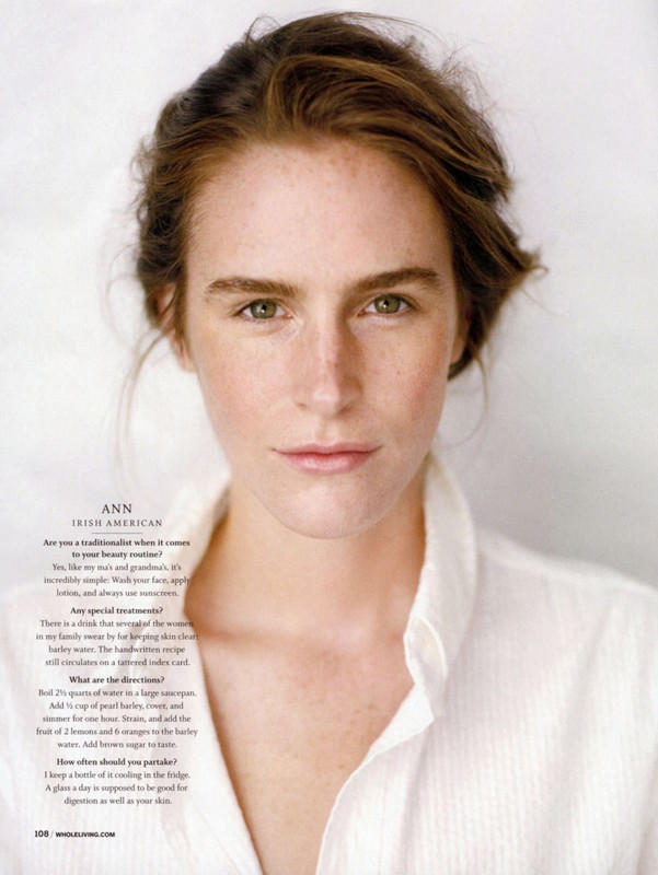 Portrait of an adult woman with fair skin and light brown hair. She wears a white button-down shirt against a bright background.