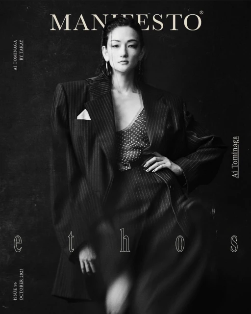 Monochrome fashion portrait of a stylish Asian woman in a pinstripe blazer on a magazine cover with text overlays and black backdrop.
