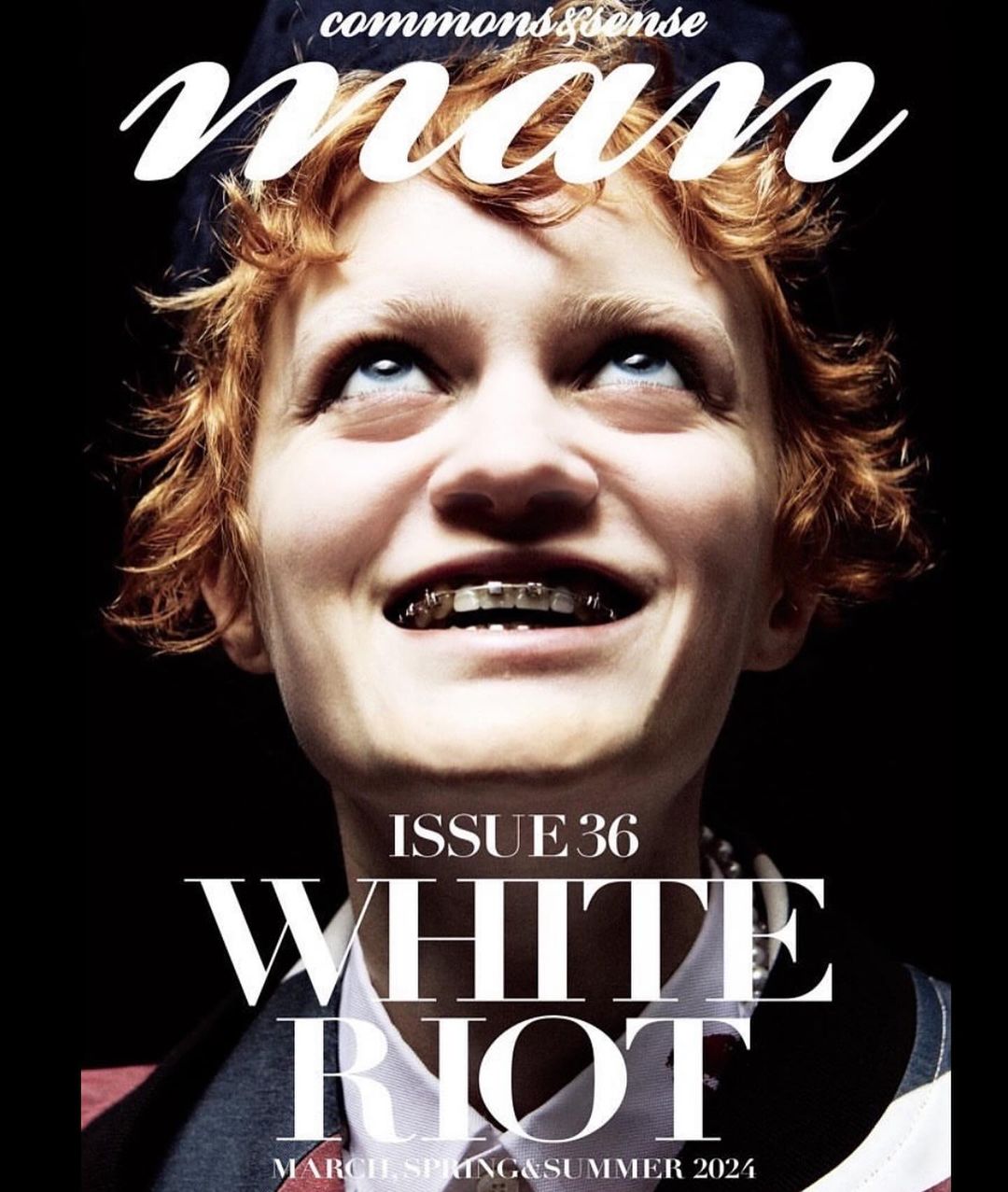 Magazine cover featuring a young adult with red hair looking up, wearing braces, and a collared jacket on a black background.
