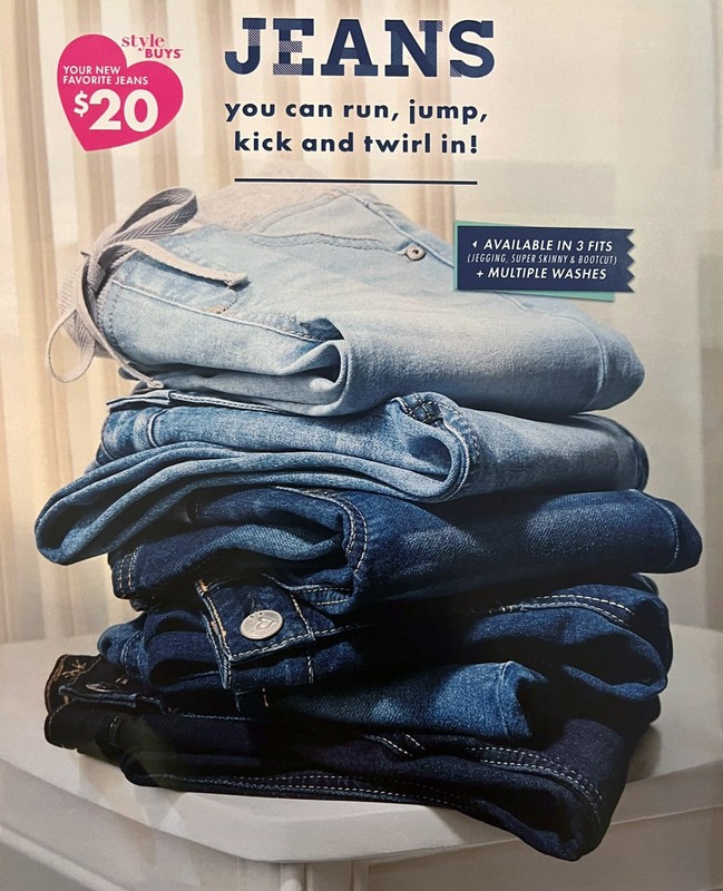 Stack of folded denim jeans on a white table, advertising Style Buys for $20, promoting the availability in three fits and multiple washes.