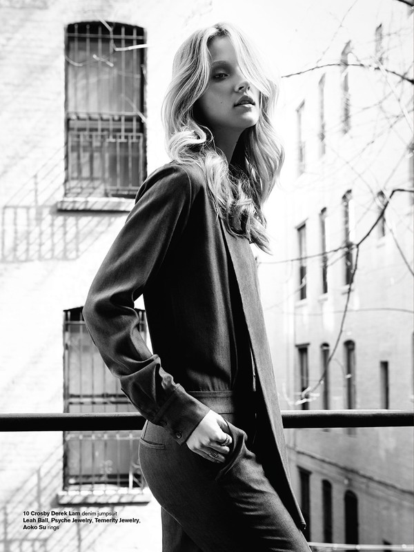 Monochrome fashion portrait of a female model outdoors against a building exterior with barred windows, styled by Tatiana Cinquino.