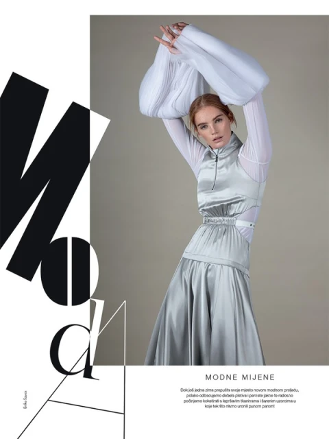 A model showcases a silver dress and white top with puffed sleeves in a fashion editorial against a neutral background with graphic text.